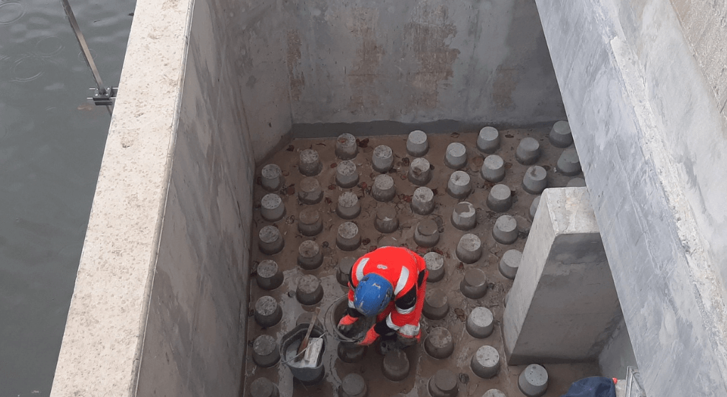 Installation des plots macro rugosité en béton préfabriqué sur la passe à poissons